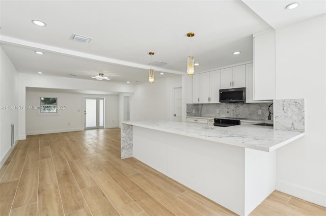 2001 SW 23rd Ave, Fort Lauderdale, FL 33312 - kitchen featuring stainless steel microwave, white cabinetry, backsplash, light stone counters, and recessed lighting
