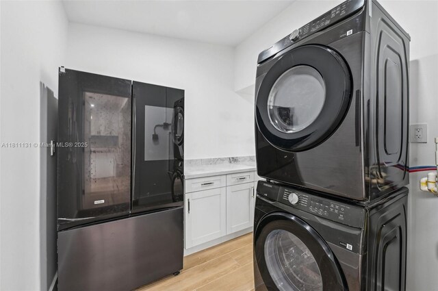 2001 SW 23rd Ave, Fort Lauderdale, FL 33312 - laundry room featuring estacked washer and dryer, light wood-style floors, and cabinet space