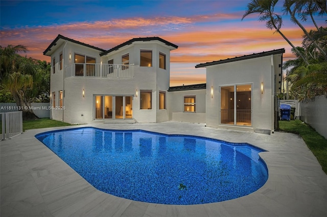 2001 SW 23rd Ave, Fort Lauderdale, FL 33312 - back of property at dusk with a balcony, stucco siding, a fenced backyard, and a patio