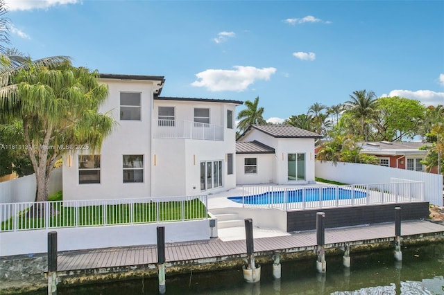 2001 SW 23rd Ave, Fort Lauderdale, FL 33312 - rear view of house with a balcony, stucco siding, a fenced backyard, a water view, and a standing seam roof