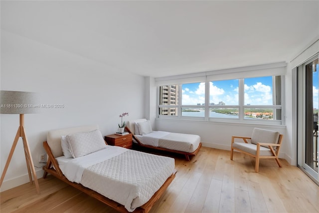 2 Grove Isle Dr Unit B1108, Miami, FL 33133 - bedroom featuring light wood-type flooring, baseboards, and a water view