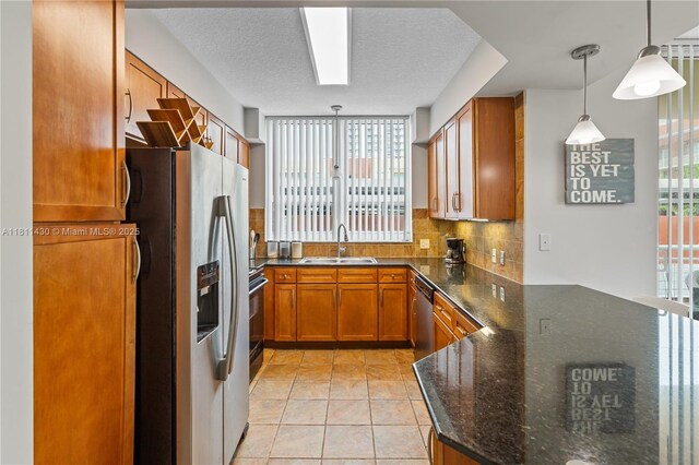 2000 N Bayshore Dr Unit 401, Miami, FL 33137 - kitchen with stainless steel refrigerator with ice dispenser, a sink, brown cabinetry, a peninsula, and decorative light fixtures