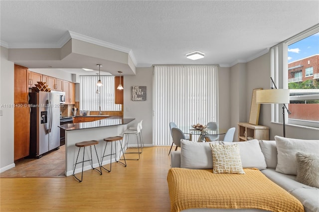 2000 N Bayshore Dr Unit 401, Miami, FL 33137 - living room featuring light wood-style floors, ornamental molding, a textured ceiling, and baseboards