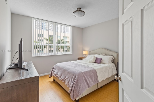 2000 N Bayshore Dr Unit 401, Miami, FL 33137 - bedroom with light wood finished floors, a textured ceiling, and baseboards