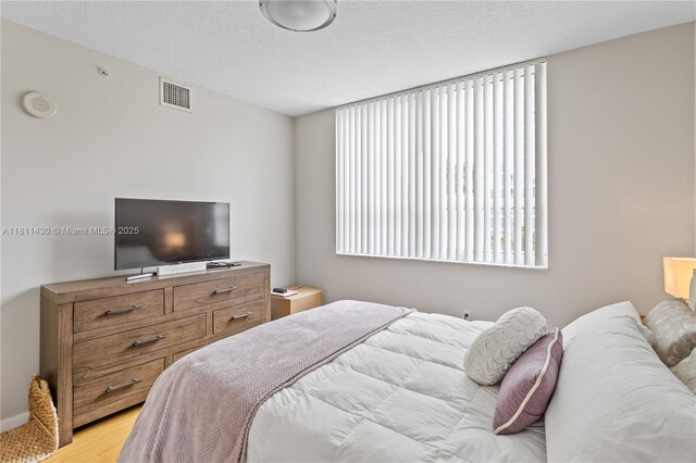 2000 N Bayshore Dr Unit 401, Miami, FL 33137 - bedroom with light wood-type flooring and a textured ceiling