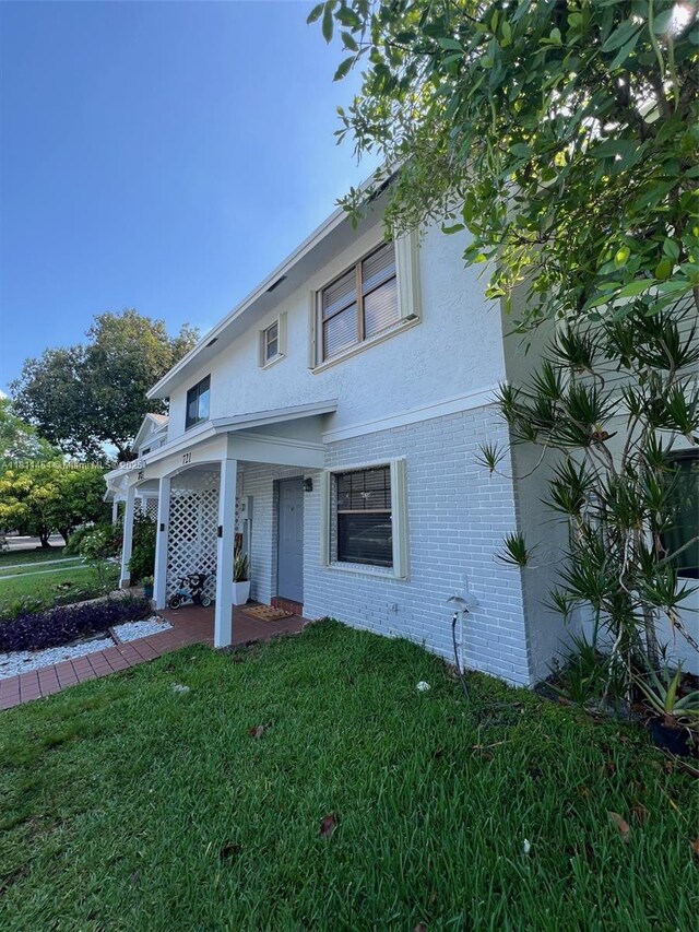 721 NW 105th Ter Unit 721, Pembroke Pines, FL 33026 - traditional-style house with brick siding, a front yard, and stucco siding