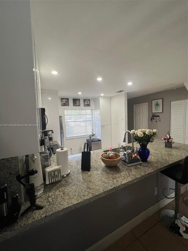 721 NW 105th Ter Unit 721, Pembroke Pines, FL 33026 - kitchen with stone countertops, a kitchen breakfast bar, and recessed lighting