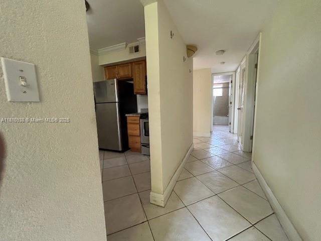 8475 SW 94th St Unit 116E, Miami, FL 33156 - corridor with light tile patterned flooring, baseboards, and a textured wall
