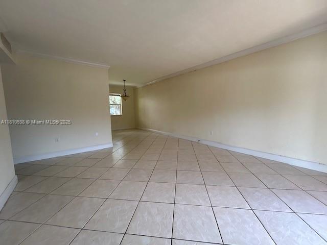 8475 SW 94th St Unit 116E, Miami, FL 33156 - empty room with crown molding, baseboards, and light tile patterned floors