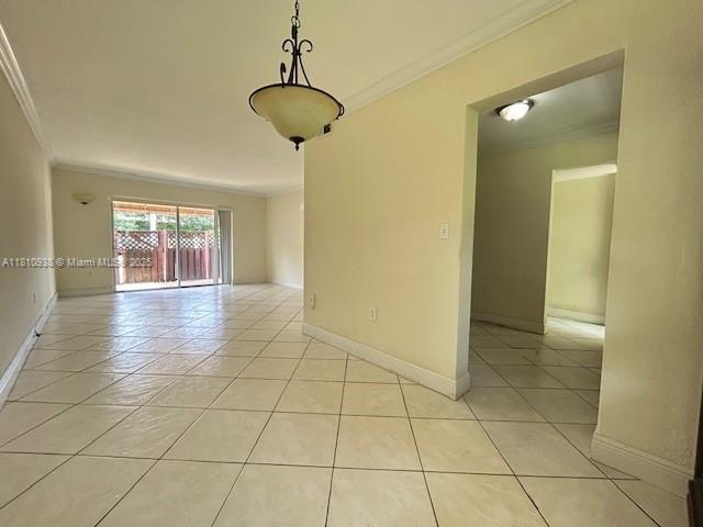 8475 SW 94th St Unit 116E, Miami, FL 33156 - empty room featuring crown molding, light tile patterned flooring, and baseboards
