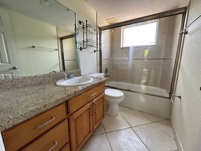 8475 SW 94th St Unit 116E, Miami, FL 33156 - full bathroom with toilet, vanity, combined bath / shower with glass door, a textured wall, and tile patterned flooring