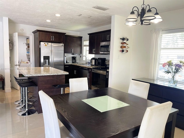 4752 SW 127th Ct, Miami, FL 33175 - dining room with a chandelier, light tile patterned floors, and a textured ceiling