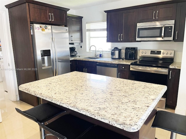 4752 SW 127th Ct, Miami, FL 33175 - kitchen with stainless steel appliances, a kitchen bar, and light stone countertops