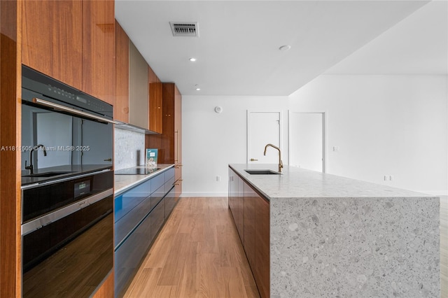2678 Tigertail Ave Unit 513, Coconut Grove, FL 33133 - kitchen with modern cabinets, a sink, a kitchen island with sink, black appliances, and recessed lighting