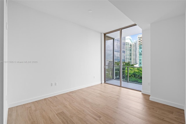 2678 Tigertail Ave Unit 513, Coconut Grove, FL 33133 - empty room featuring expansive windows, wood finished floors, a view of city, and baseboards