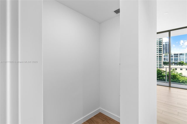 2678 Tigertail Ave Unit 513, Coconut Grove, FL 33133 - spare room featuring wood finished floors, floor to ceiling windows, and baseboards