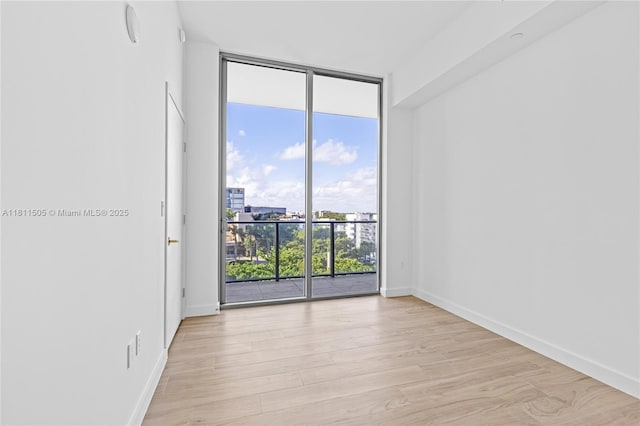 2678 Tigertail Ave Unit 513, Coconut Grove, FL 33133 - empty room with floor to ceiling windows, light wood-type flooring, and baseboards