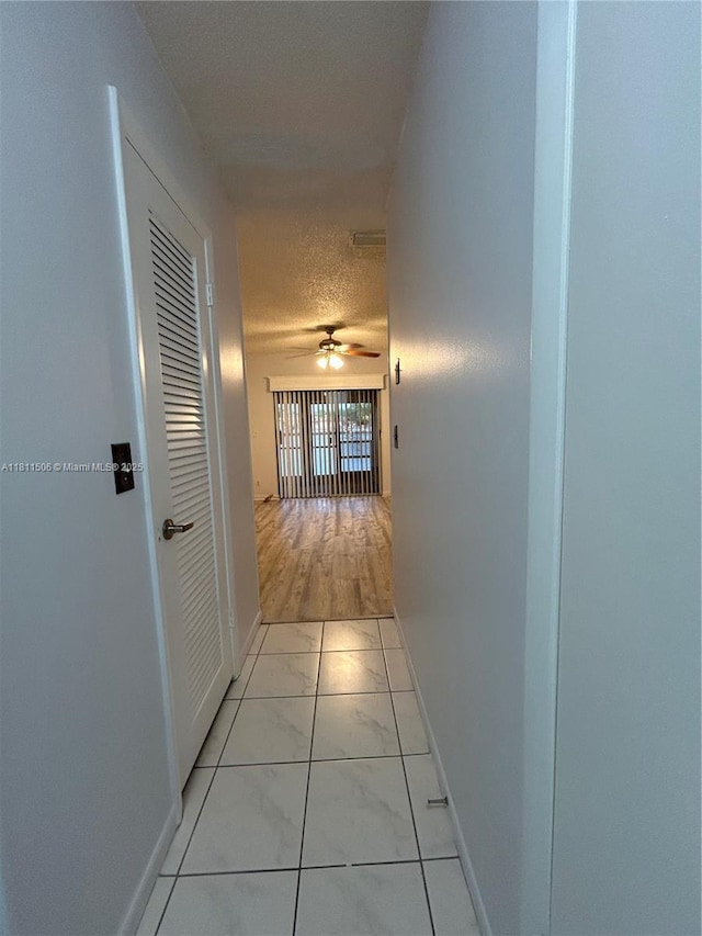 322 Briarwood Cir Unit 1-17, Hollywood, FL 33024 - hall with light marble finish flooring, baseboards, and a textured ceiling