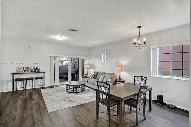 1001 NW 100th Ave, Pembroke Pines, FL 33024 - dining area featuring wood finished floors, a textured ceiling, a chandelier, and baseboards