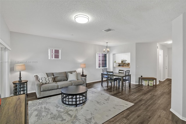 1001 NW 100th Ave, Pembroke Pines, FL 33024 - living area with dark wood finished floors, a chandelier, a textured ceiling, and baseboards