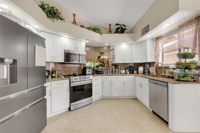 3831 NW 21st St, Coconut Creek, FL 33066 - kitchen featuring appliances with stainless steel finishes, a sink, backsplash, lofted ceiling, and light stone counters