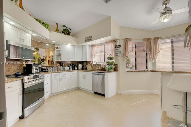 3831 NW 21st St, Coconut Creek, FL 33066 - kitchen with appliances with stainless steel finishes, a sink, decorative backsplash, white cabinetry, and lofted ceiling