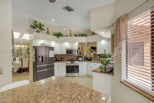 3831 NW 21st St, Coconut Creek, FL 33066 - kitchen featuring appliances with stainless steel finishes, light stone counters, decorative backsplash, white cabinets, and lofted ceiling