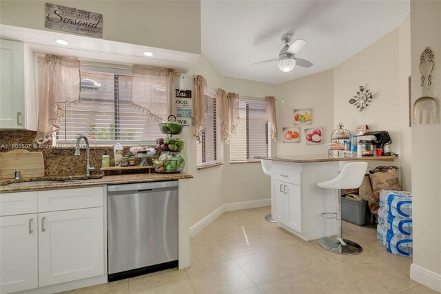 3831 NW 21st St, Coconut Creek, FL 33066 - kitchen with stainless steel dishwasher, ceiling fan, white cabinets, stone counters, and baseboards