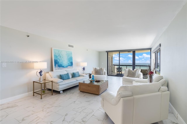 812 N Ocean Blvd Unit 405, Pompano Beach, FL 33062 - living area with a wall of windows, baseboards, and light marble finish flooring