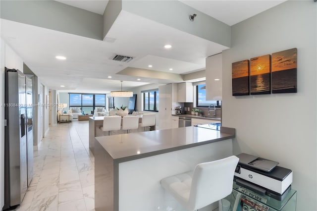 812 N Ocean Blvd Unit 405, Pompano Beach, FL 33062 - kitchen with open floor plan, recessed lighting, white cabinets, light marble finish floors, and plenty of natural light