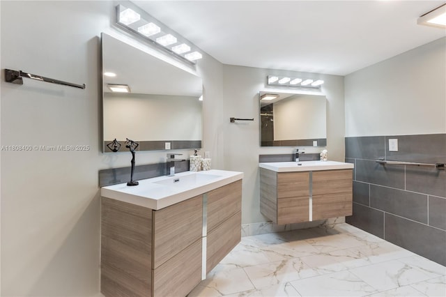 812 N Ocean Blvd Unit 405, Pompano Beach, FL 33062 - bathroom featuring two vanities, marble look tile flooring, and tile walls