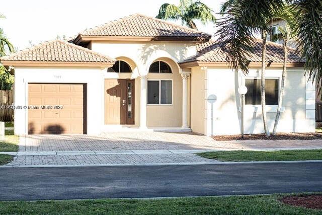 1371 NE 42nd Ave, Homestead, FL 33033 - mediterranean / spanish-style house with stucco siding, a garage, a tiled roof, and decorative driveway