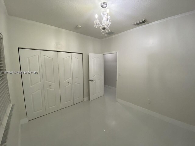 1371 NE 42nd Ave, Homestead, FL 33033 - unfurnished bedroom featuring a chandelier, crown molding, a closet, and finished concrete flooring