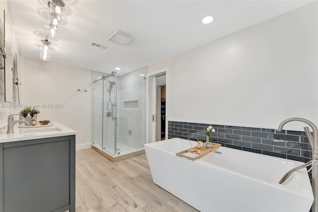 651 E Lake Dasha Dr, Plantation, FL 33324 - full bath with a shower stall, a walk in closet, vanity, a freestanding bath, and wood finished floors