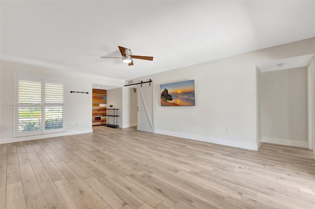 651 E Lake Dasha Dr, Plantation, FL 33324 - unfurnished living room featuring a barn door, light wood-style flooring, a ceiling fan, and baseboards