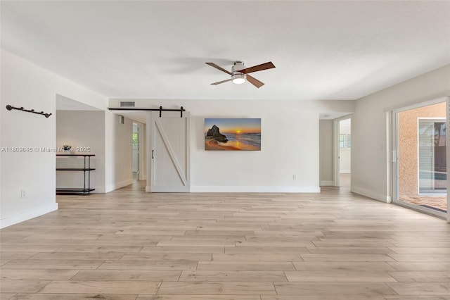 651 E Lake Dasha Dr, Plantation, FL 33324 - empty room featuring a barn door, light wood finished floors, ceiling fan, and baseboards