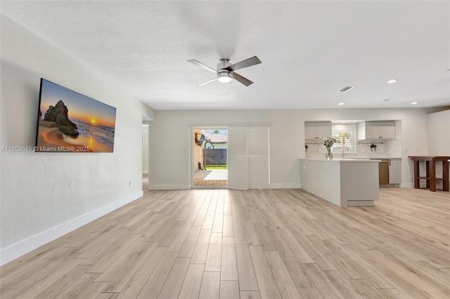 651 E Lake Dasha Dr, Plantation, FL 33324 - unfurnished living room featuring light wood-style flooring, a ceiling fan, baseboards, recessed lighting, and a sink