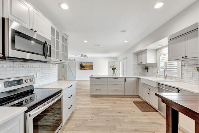 651 E Lake Dasha Dr, Plantation, FL 33324 - kitchen with appliances with stainless steel finishes, a peninsula, tasteful backsplash, recessed lighting, and a ceiling fan