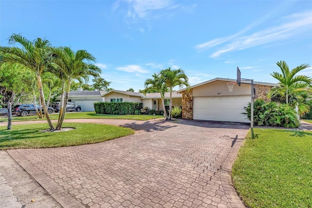 651 E Lake Dasha Dr, Plantation, FL 33324 - single story home with decorative driveway, stone siding, a front yard, and an attached garage