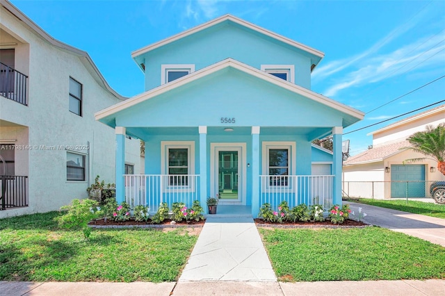 5565 SW 43rd St, Davie, FL 33314 - view of front facade featuring covered porch, stucco siding, a front lawn, and concrete driveway