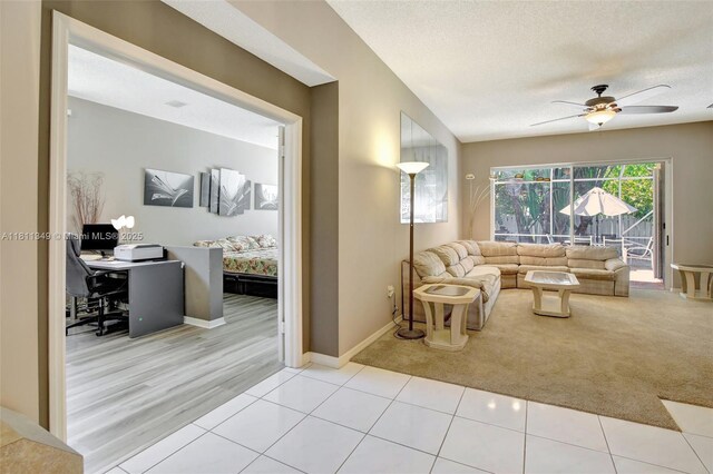 13220 NW 11th Ct, Sunrise, FL 33323 - tiled living room with carpet floors, a ceiling fan, a textured ceiling, and a desk