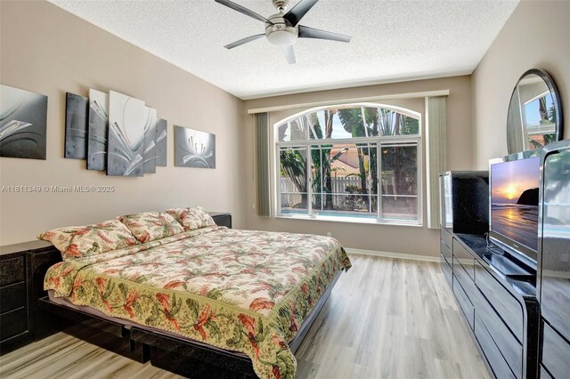 13220 NW 11th Ct, Sunrise, FL 33323 - bedroom featuring multiple windows, wood finished floors, a textured ceiling, and a ceiling fan