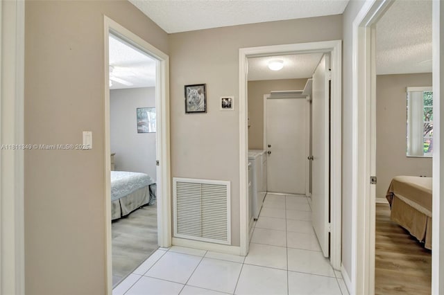 13220 NW 11th Ct, Sunrise, FL 33323 - hallway featuring washer and clothes dryer, a textured ceiling, and light tile patterned floors