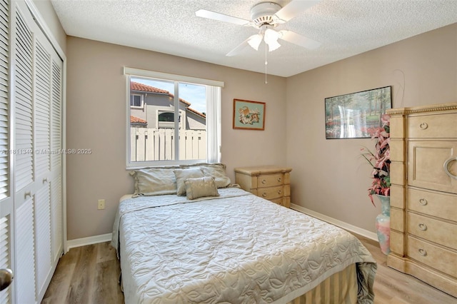 13220 NW 11th Ct, Sunrise, FL 33323 - bedroom with light wood finished floors, a textured ceiling, a closet, and a ceiling fan