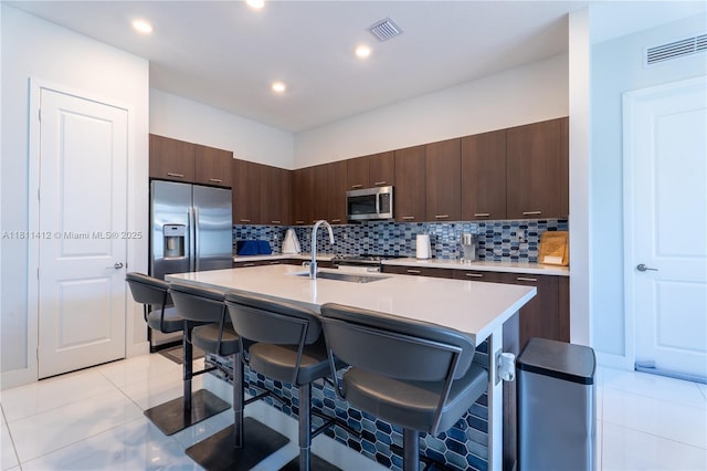 4366 SW 174th Ave, Miramar, FL 33029 - kitchen with stainless steel appliances, a kitchen breakfast bar, light countertops, light tile patterned flooring, and a sink