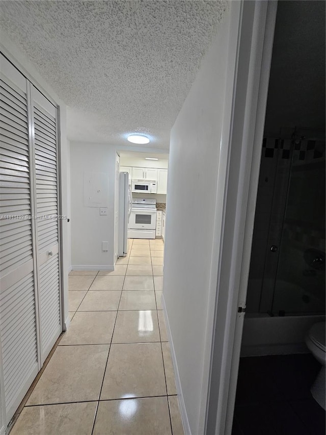 8475 SW 156th Ct Unit 321, Miami, FL 33193 - hall with a textured ceiling, light tile patterned floors, and baseboards