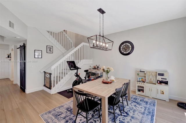4413 NW 97th Pl, Doral, FL 33178 - dining space featuring a barn door, stairway, light wood-style floors, and baseboards