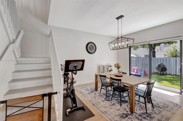 4413 NW 97th Pl, Doral, FL 33178 - dining area featuring stairway, wood finished floors, a chandelier, and baseboards