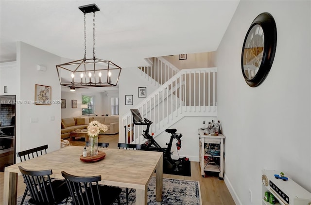 4413 NW 97th Pl, Doral, FL 33178 - dining room with light wood-style flooring, stairway, a chandelier, and baseboards