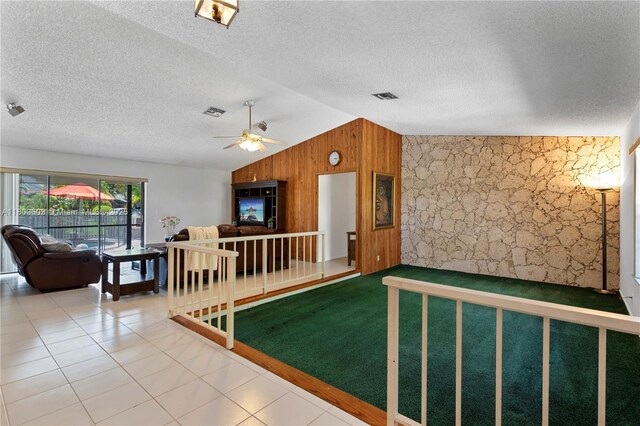 988 NW 110th Ave, Coral Springs, FL 33071 - living room with wooden walls, lofted ceiling, an accent wall, a textured ceiling, and ceiling fan